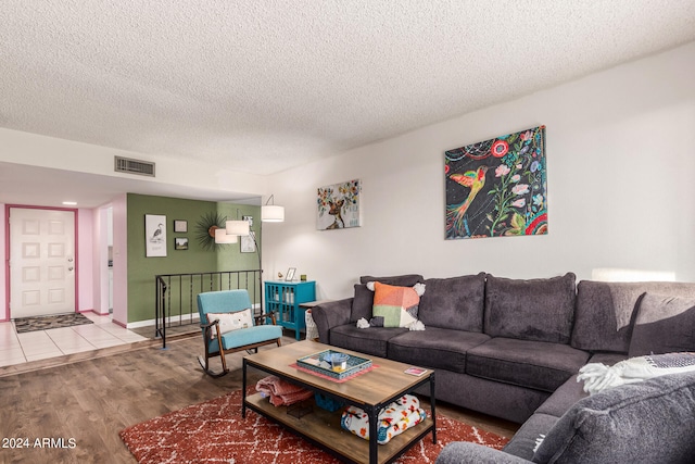 living room with a textured ceiling and hardwood / wood-style flooring