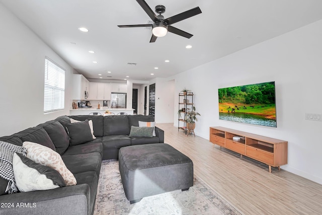 living room featuring recessed lighting, visible vents, light wood-style flooring, and baseboards