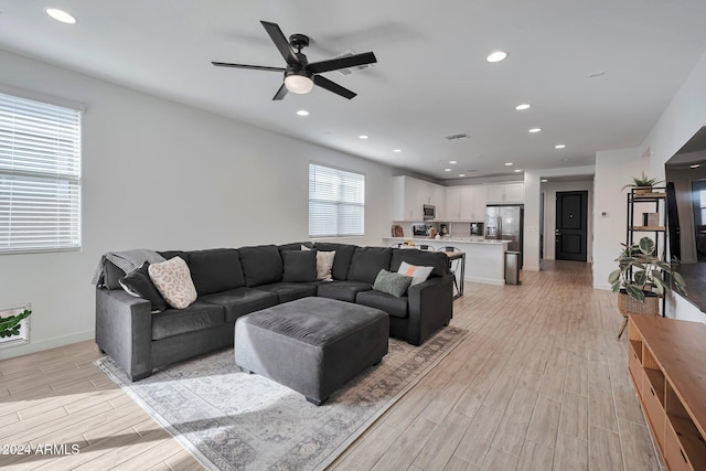 living room with light wood-style flooring, baseboards, ceiling fan, and recessed lighting