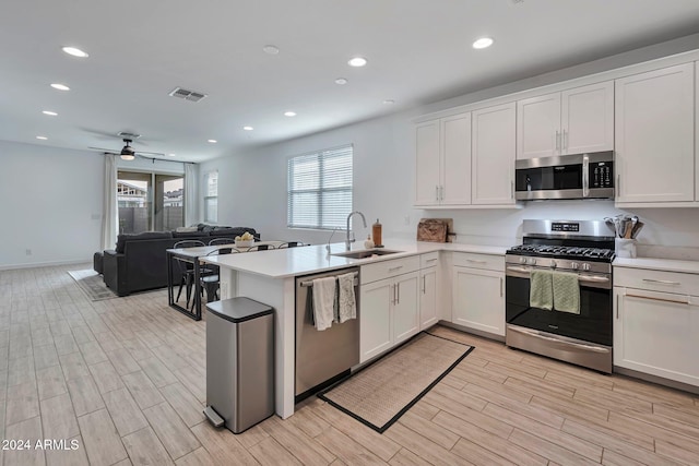 kitchen featuring stainless steel appliances, light countertops, a sink, and visible vents