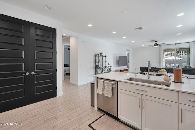 kitchen featuring a sink, visible vents, open floor plan, light countertops, and stainless steel dishwasher