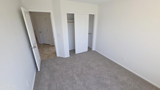 unfurnished bedroom featuring a closet, carpet flooring, and baseboards