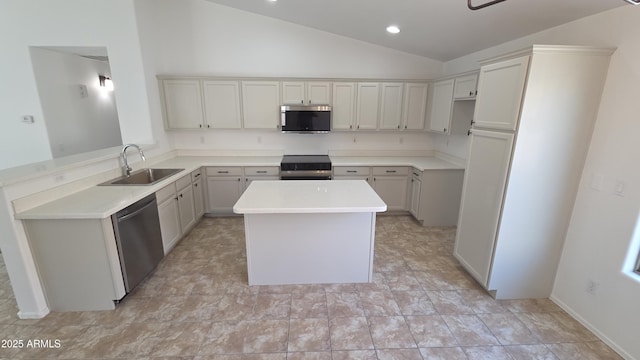 kitchen featuring light countertops, a sink, a kitchen island, appliances with stainless steel finishes, and lofted ceiling