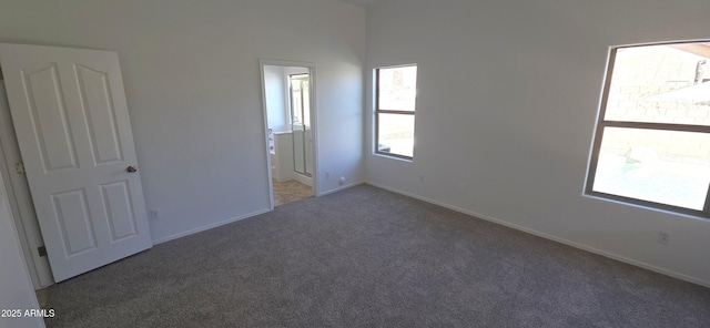 interior space with baseboards, ensuite bath, and carpet