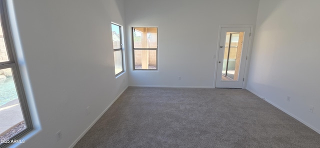 unfurnished room with carpet floors and baseboards