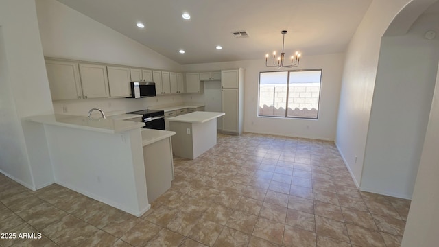 kitchen featuring light countertops, a sink, stainless steel microwave, electric stove, and visible vents