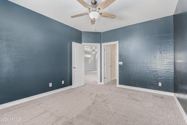 spare room featuring ceiling fan and carpet