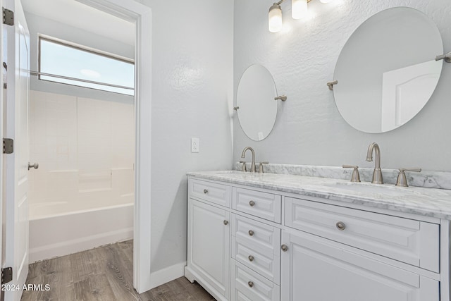 bathroom with wood-type flooring, vanity, and shower / bath combination