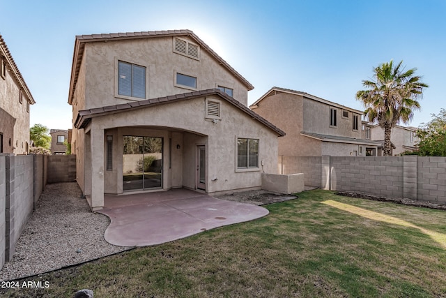 back of property featuring a yard and a patio area