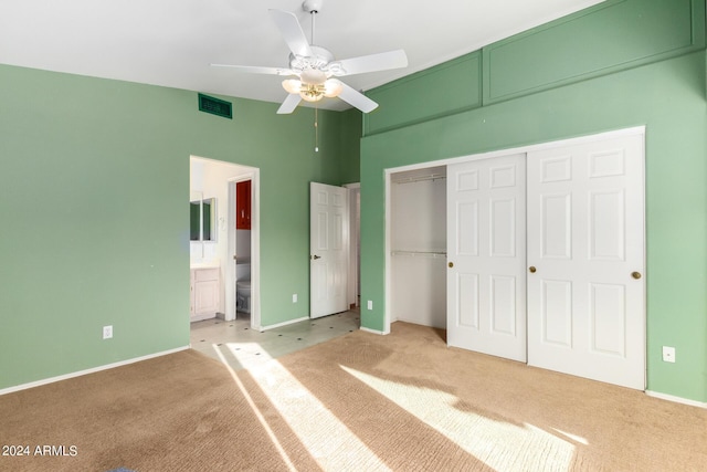 unfurnished bedroom featuring ceiling fan, light colored carpet, connected bathroom, and a closet