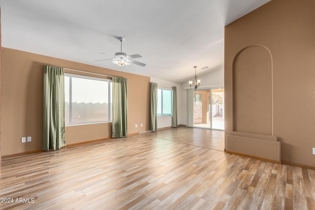 unfurnished room featuring light wood-type flooring, vaulted ceiling, and ceiling fan with notable chandelier