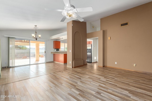 unfurnished living room with light wood-type flooring, vaulted ceiling, and ceiling fan with notable chandelier