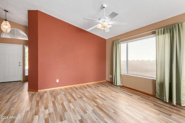 interior space featuring lofted ceiling, ceiling fan with notable chandelier, and light hardwood / wood-style flooring