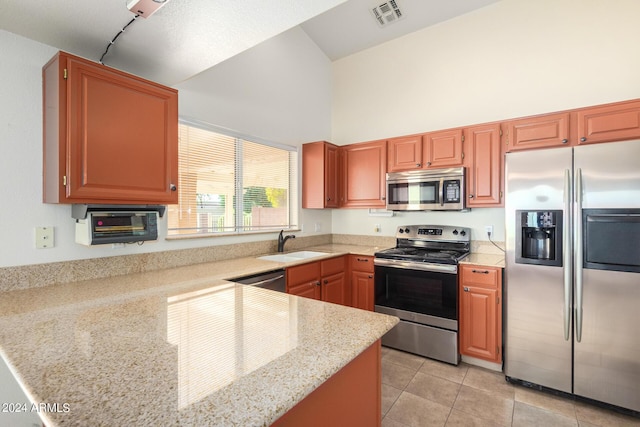 kitchen featuring stainless steel appliances, a high ceiling, light tile patterned flooring, light stone counters, and sink