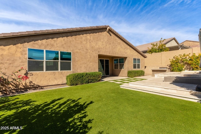 rear view of house featuring a patio area and a lawn