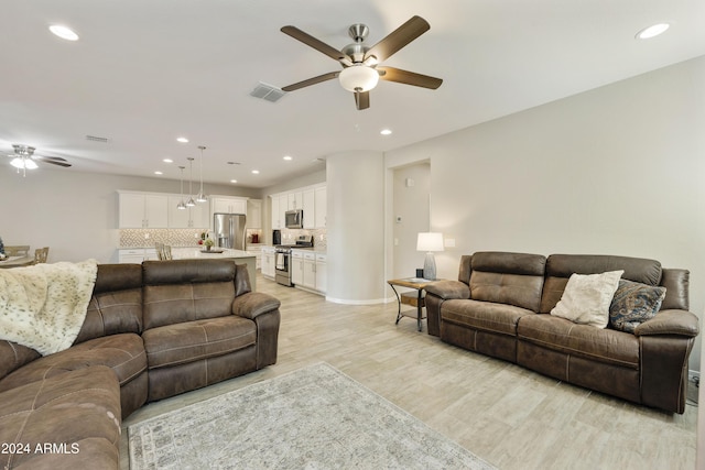 living room with ceiling fan and light wood-type flooring