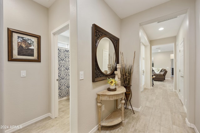 corridor with light hardwood / wood-style floors