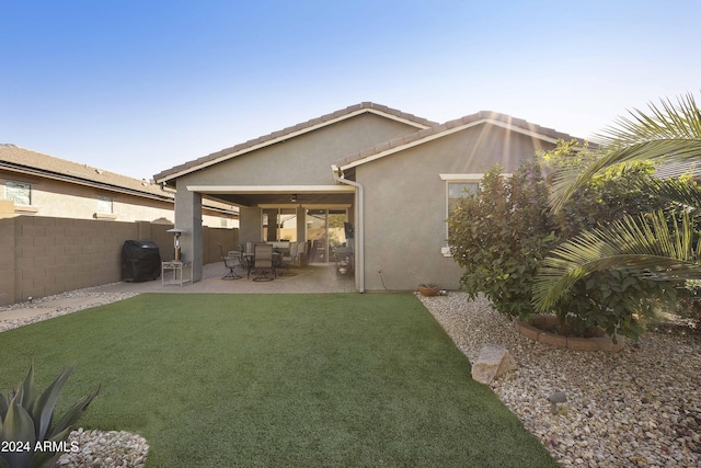 rear view of property featuring a yard and a patio