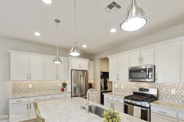 kitchen with white cabinets, decorative light fixtures, stainless steel appliances, and tasteful backsplash