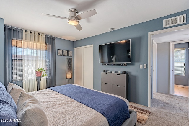 bedroom with carpet floors, ceiling fan, and a closet