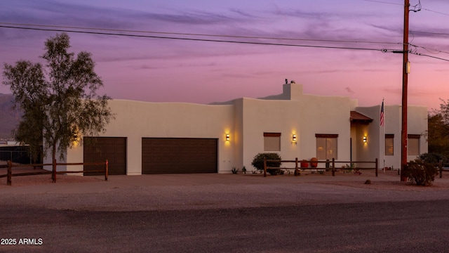 pueblo revival-style home with a garage