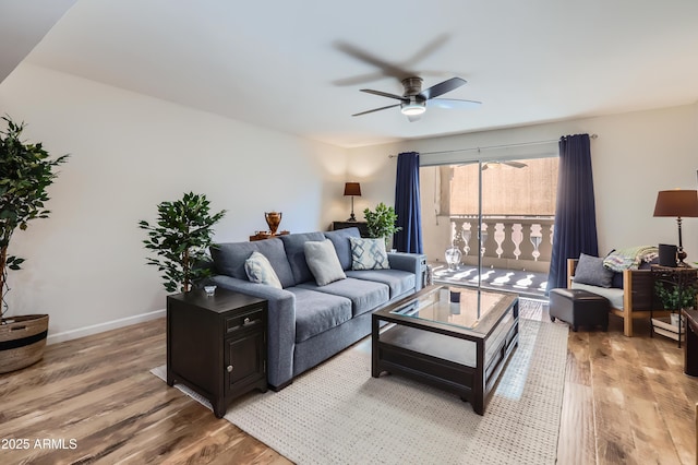 living area with light wood-style floors, ceiling fan, and baseboards