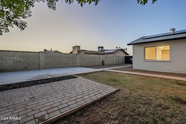 yard at dusk featuring a patio area