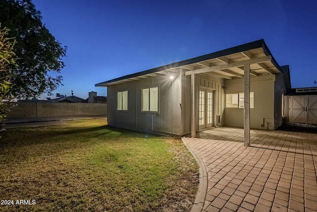 back of house with a lawn, a patio area, and french doors