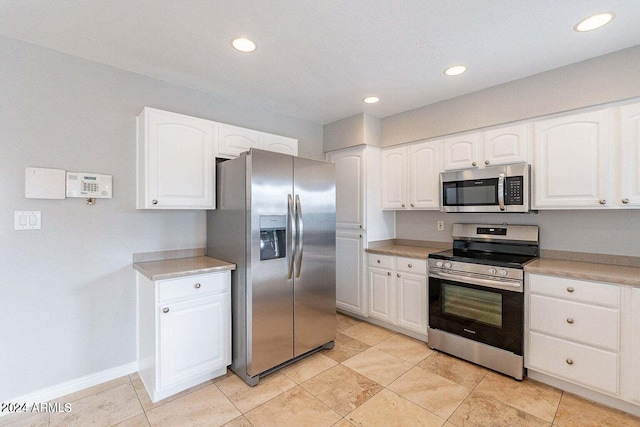 kitchen featuring light tile patterned flooring, white cabinetry, and stainless steel appliances