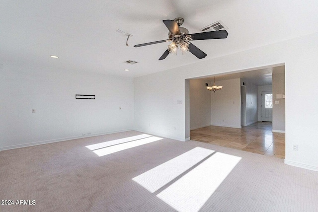 spare room with light carpet and ceiling fan with notable chandelier