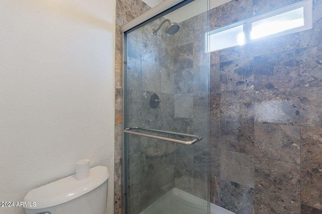 bathroom featuring an enclosed shower and toilet