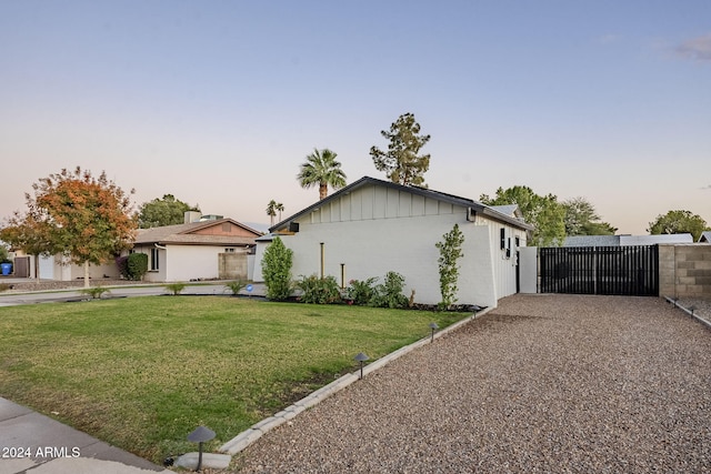 property exterior at dusk with a lawn