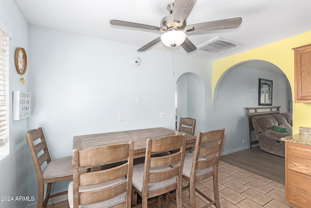 dining area with light wood-type flooring and ceiling fan