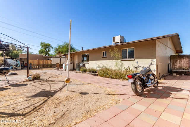 back of property with central AC and a patio area