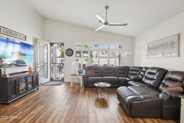 living room featuring dark wood-type flooring, ceiling fan, and vaulted ceiling