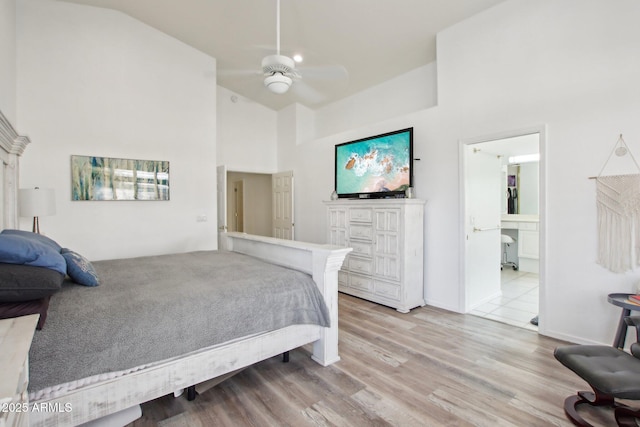 bedroom featuring ensuite bath, high vaulted ceiling, ceiling fan, and light wood-type flooring