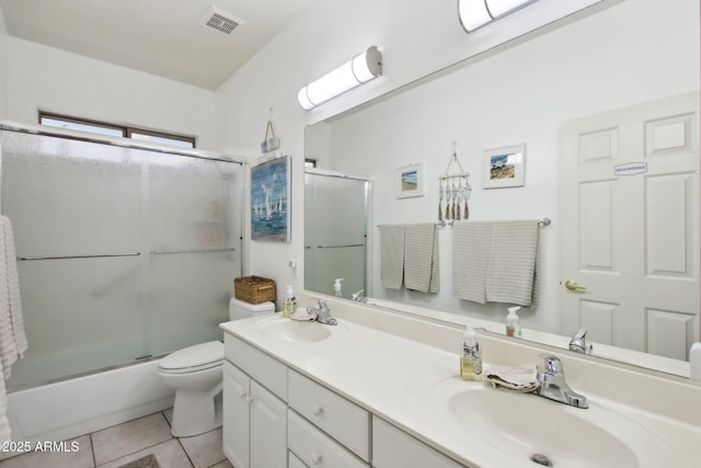 full bathroom with tile patterned flooring, vanity, bath / shower combo with glass door, and toilet