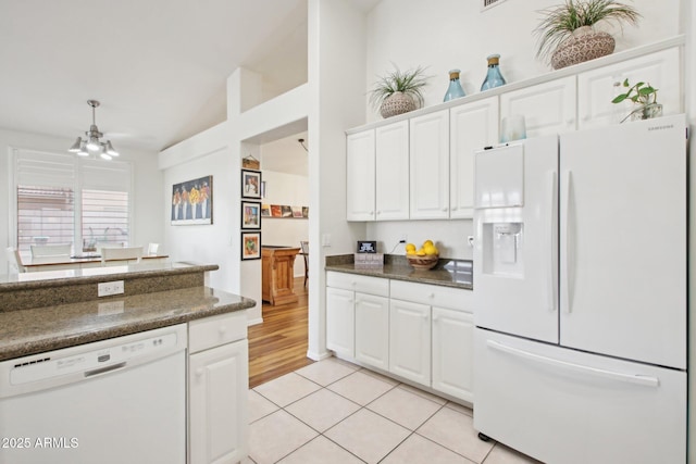 kitchen featuring light tile patterned flooring, white appliances, and white cabinets