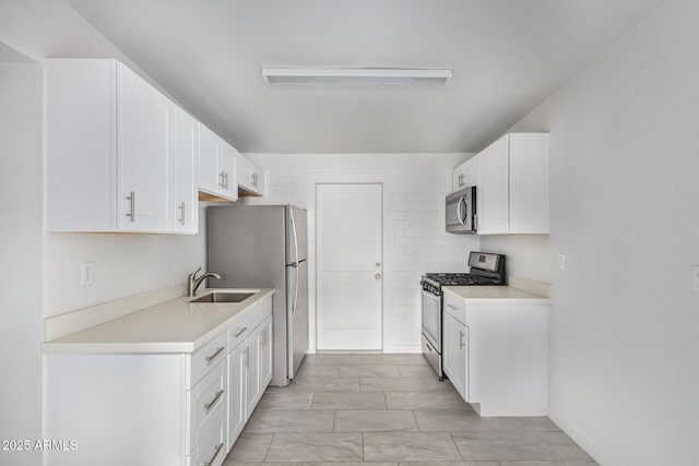 kitchen featuring stainless steel appliances, white cabinetry, and sink