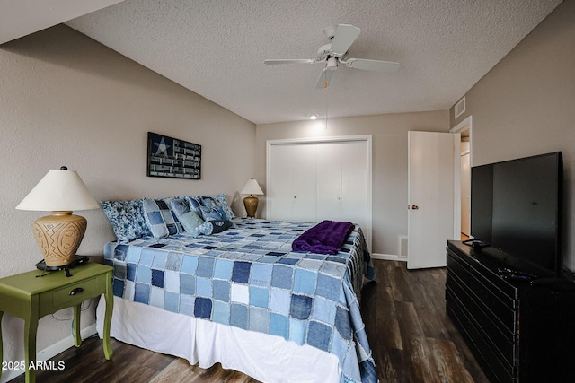 bedroom featuring a textured ceiling, a closet, dark wood-type flooring, and ceiling fan