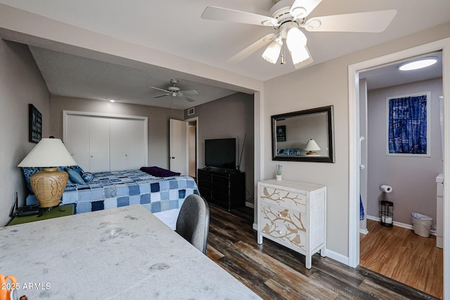 bedroom with ceiling fan, a closet, and dark hardwood / wood-style floors