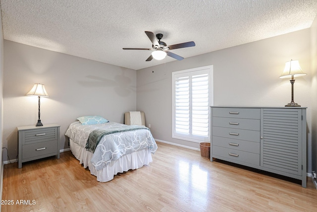 bedroom with a textured ceiling, light hardwood / wood-style flooring, and ceiling fan