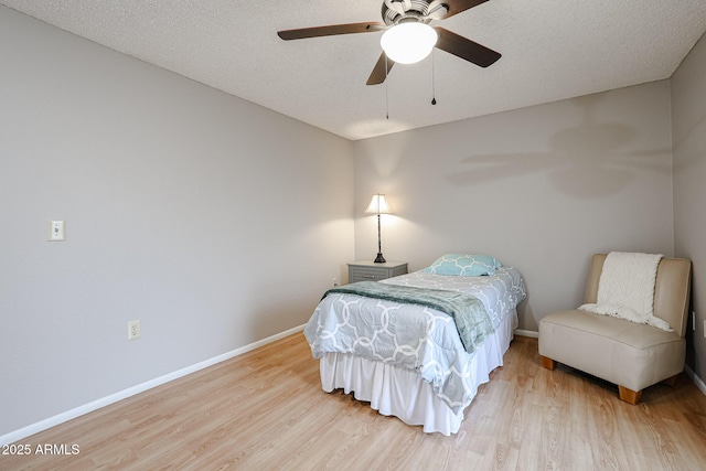 bedroom with ceiling fan, a textured ceiling, and light wood-type flooring