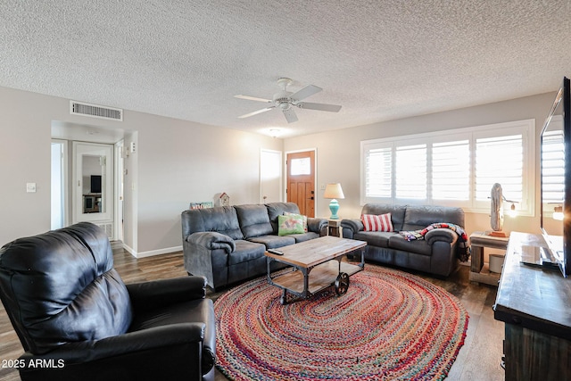 living room featuring ceiling fan, wood-type flooring, and a textured ceiling