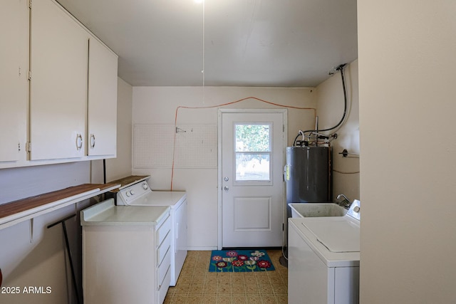 washroom featuring cabinets, sink, separate washer and dryer, and water heater