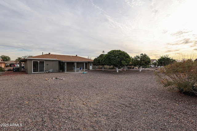 back house at dusk with a patio area