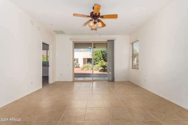 tiled spare room with ceiling fan