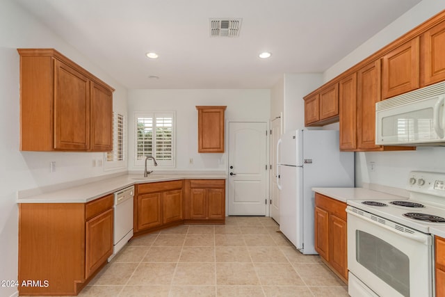 kitchen with white appliances, sink, and light tile patterned floors