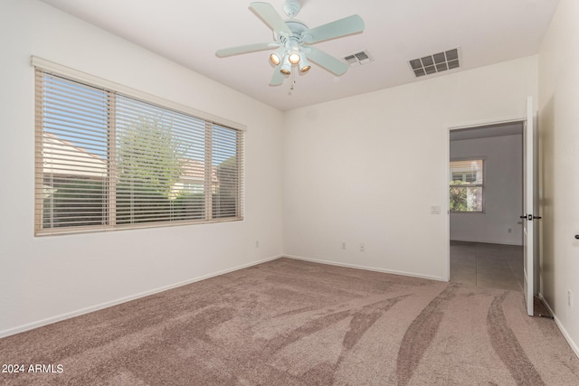 carpeted empty room featuring ceiling fan and plenty of natural light