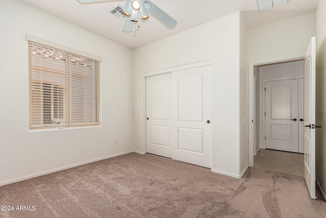 unfurnished bedroom with a closet, light colored carpet, and ceiling fan